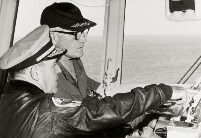 Vice Admiral John J. Hyland explains the main function of the primary flight control system to Barry Goldwater during his 18 January 1967 visit to the attack aircraft carrier USS Kitty Hawk (CVA-63) in the Tonkin Gulf.