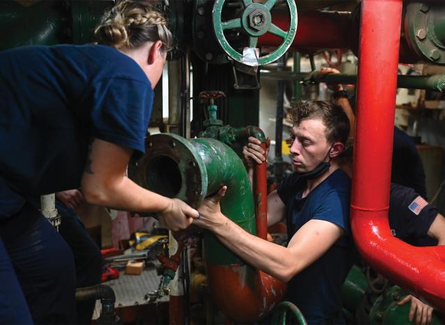 Engineers on board the USCGC Thetis (WMEC-910) work to replace a seawater pump to get the cutter fully mission capable. One way to increase skills and knowledge in the engine room would be platform specialization—having mechanics trained on specific engine models and continuing to work on those models in subsequent tours.