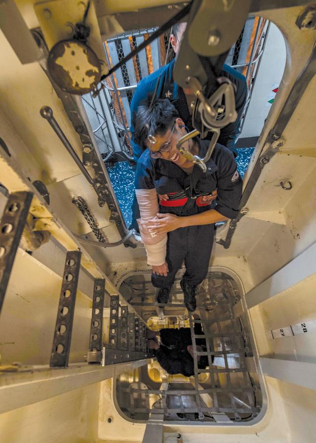 Sailor acts acts as a personnel casualty being hoisted out of shaft alley during a damage control drill
