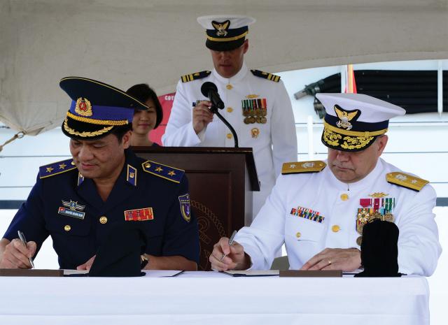 Lieutenant General Nguyen Quang Dam, Commandant, Vietnam Coast Guard, and Rear Admiral Michael J. Haycock, Assistant Commandant for Acquisition and Chief Acquisition Officer, U.S. Coast Guard, sign documents transferring a Hamilton-class cutter (WHEC-722, the ex-Morgenthau) to Vietnam. Such transfers create training opportunities with ships the Coast Guard knows well. 