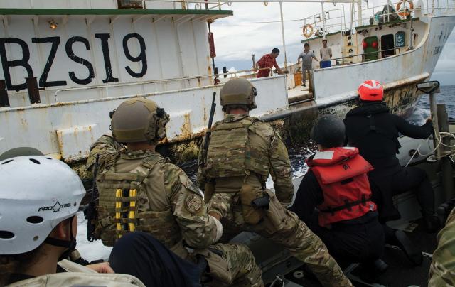 Navy sailors and a Coast Guard Pacific LEDet approach a Chinese fishing vessel in preparation for a boarding. Increased interoperability between the services would make better use of the Coast Guard’s law enforcement skills in the South China Sea and help enforce fisheries laws.  