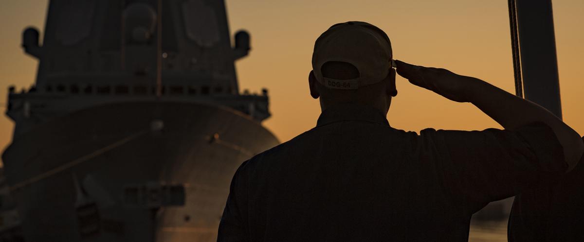 A sailor salutes the flag on board the USS Carney (DFG-64). The legacy of leaders is often in those they mentor—and those their mentees go on to lead in turn. 