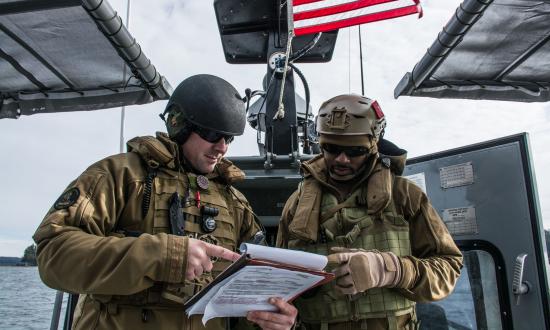 Chief Boatswain's mates review a drill guide during a Coastal Riverine navigational check ride