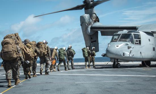 Marines prepare to load onto an MV-22 Osprey on board the USS John P. Murtha (LPD-26)