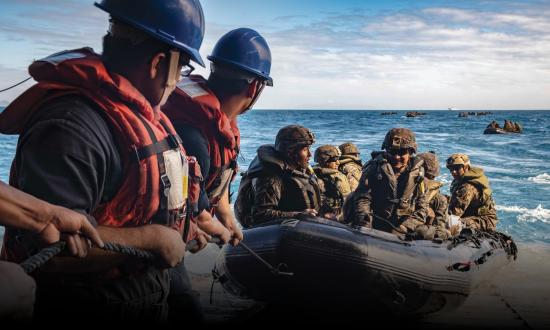 Sailors man a safety line as Marines with the 31st Marine Expeditionary Unit (MEU) stand fast on the stern gate during Combat Rubber Raiding Craft (CRRC) operations
