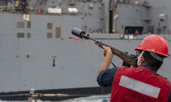 A man points a gun at a ship.