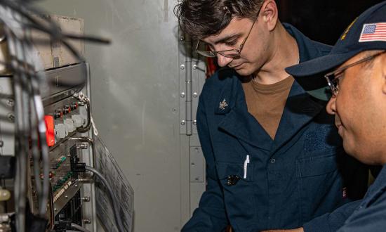 Technicians conduct SATCOM maintenance on board the USS Chancellorsville