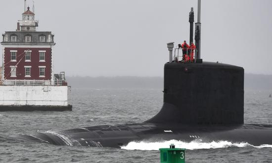 The Virginia-class fast-attack submarine USS Oregon (SSN-793) passes the New London Ledge Lighthouse during routine operations in the mouth of the Thames River in Groton, Connecticut.