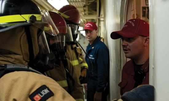 A second-class petty officer on board the USCGC Hamilton (WMSL-753) trains a fire-attack team after a damage control exercise. Leadership training earlier in the training pipeline would net more petty officers who are self-reflective leaders, capable of performing high-risk evolutions with increased autonomy.