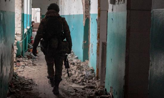 A Ukrainian soldier walks through a bombed-out school in Lyman, Ukraine, in January 2023. 
