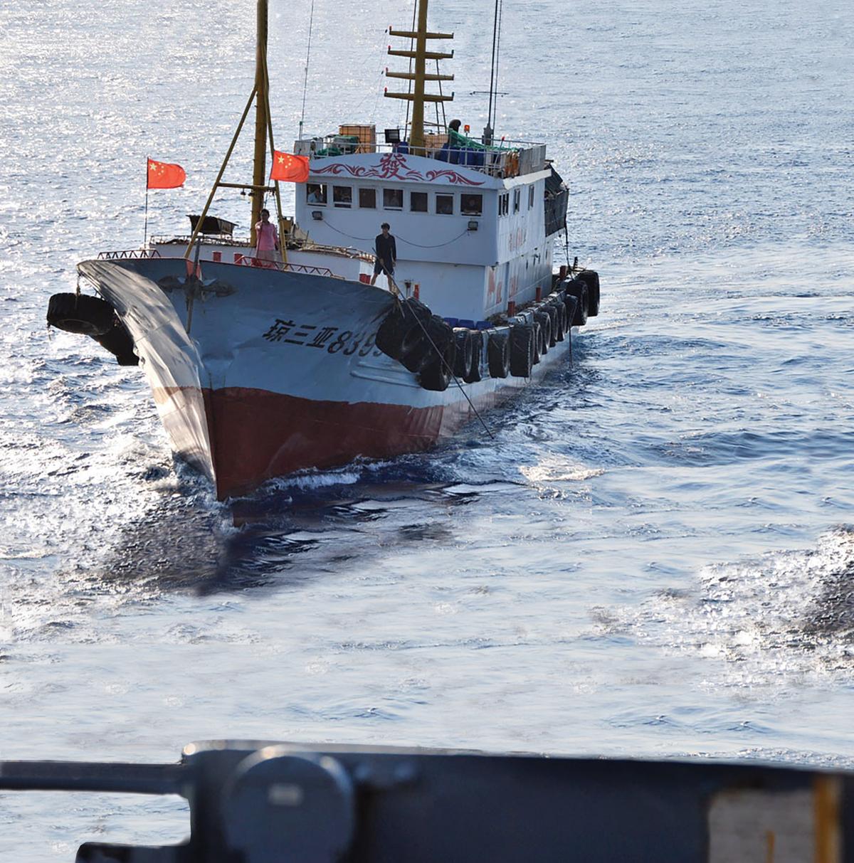 A crewmember on a Chinese trawler uses a grapple hook in an apparent attempt to snag the towed acoustic array of the military Sealift Command ocean surveillance ship USNS Impeccable (T-AGOS-23)