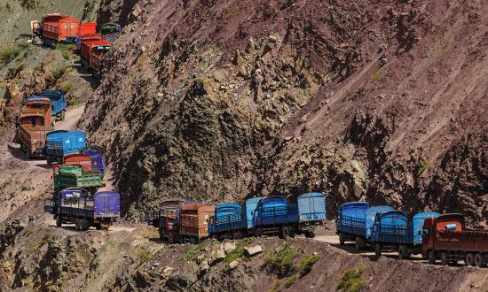 A line of Chinese trucks stuck in a traffic jam on a narrow mountain road in the Himalayas.