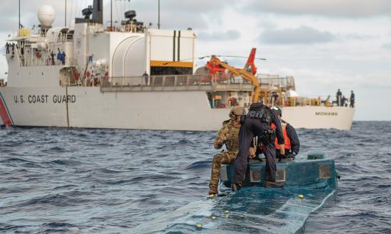 U.S. Coast Guard members offload contraband from a low-profile go-fast vessel to the U.S. Coast Guard Cutter Mohawk (WMEC-913) in the eastern Pacific.
