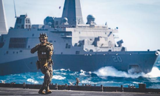 A Force Reconnaissance Marine with the 31st Marine Expeditionary Unit (MEU) clears the flight deck of the amphibious dock landing ship USS Ashland (LSD-48) 