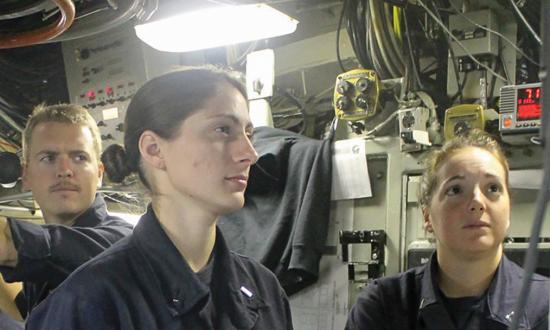Female submariners standing at a control panel
